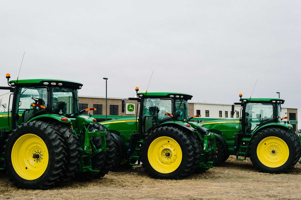 Three John Deere tractors lined up in a row